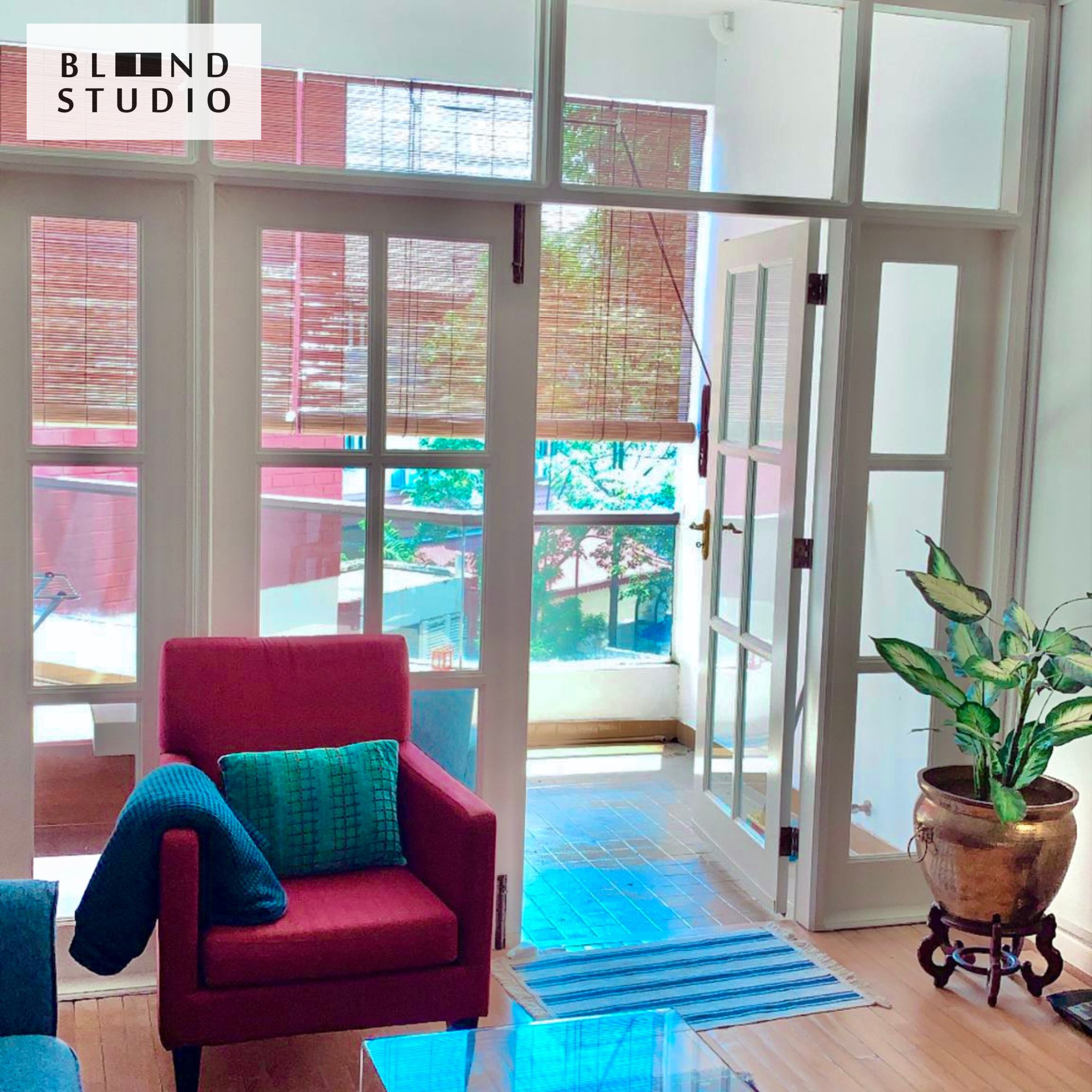 Natural Color Bamboo Blinds at the balcony with a red couch and house plant