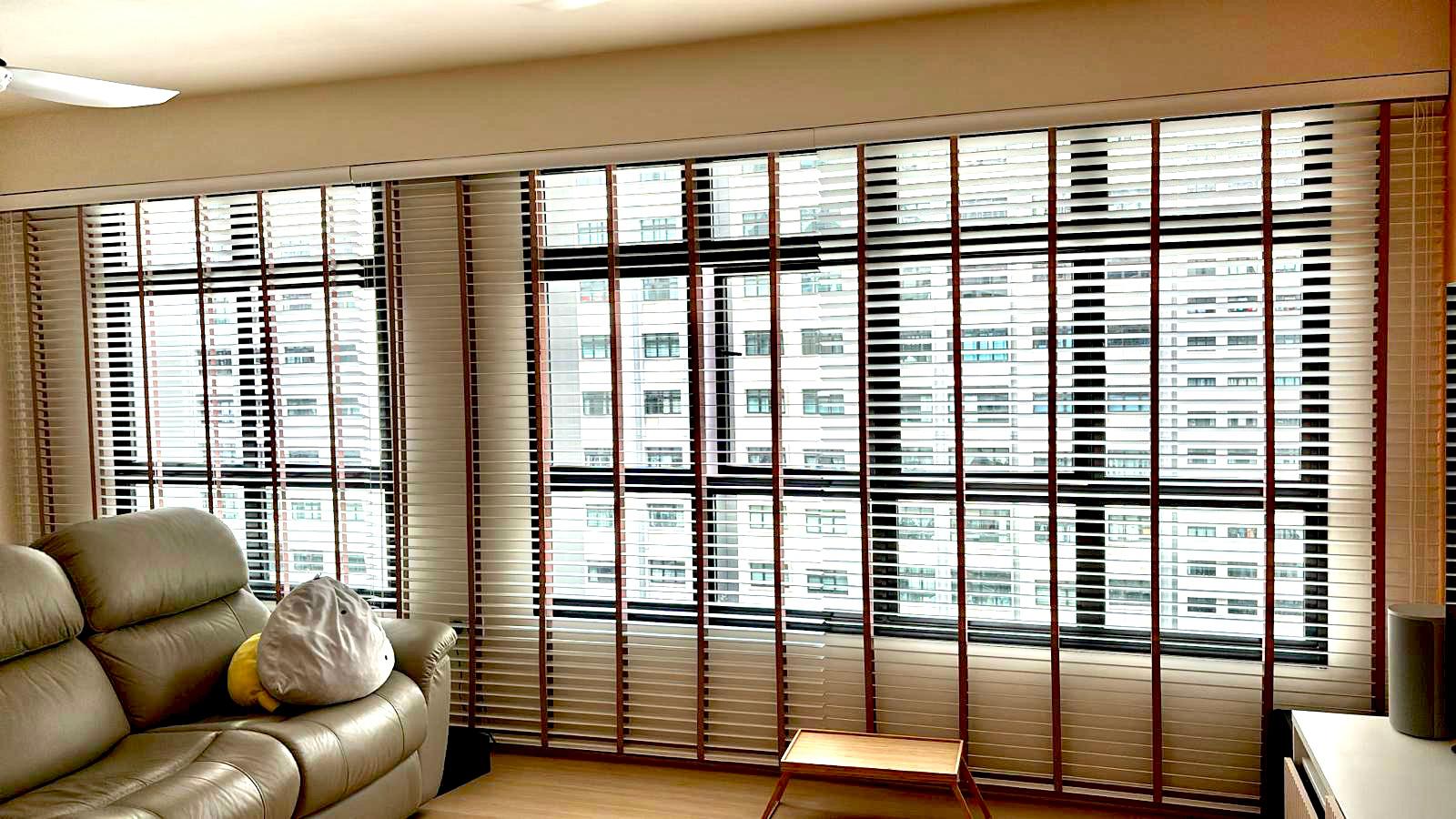 White venetian blinds with brown tape in a living room