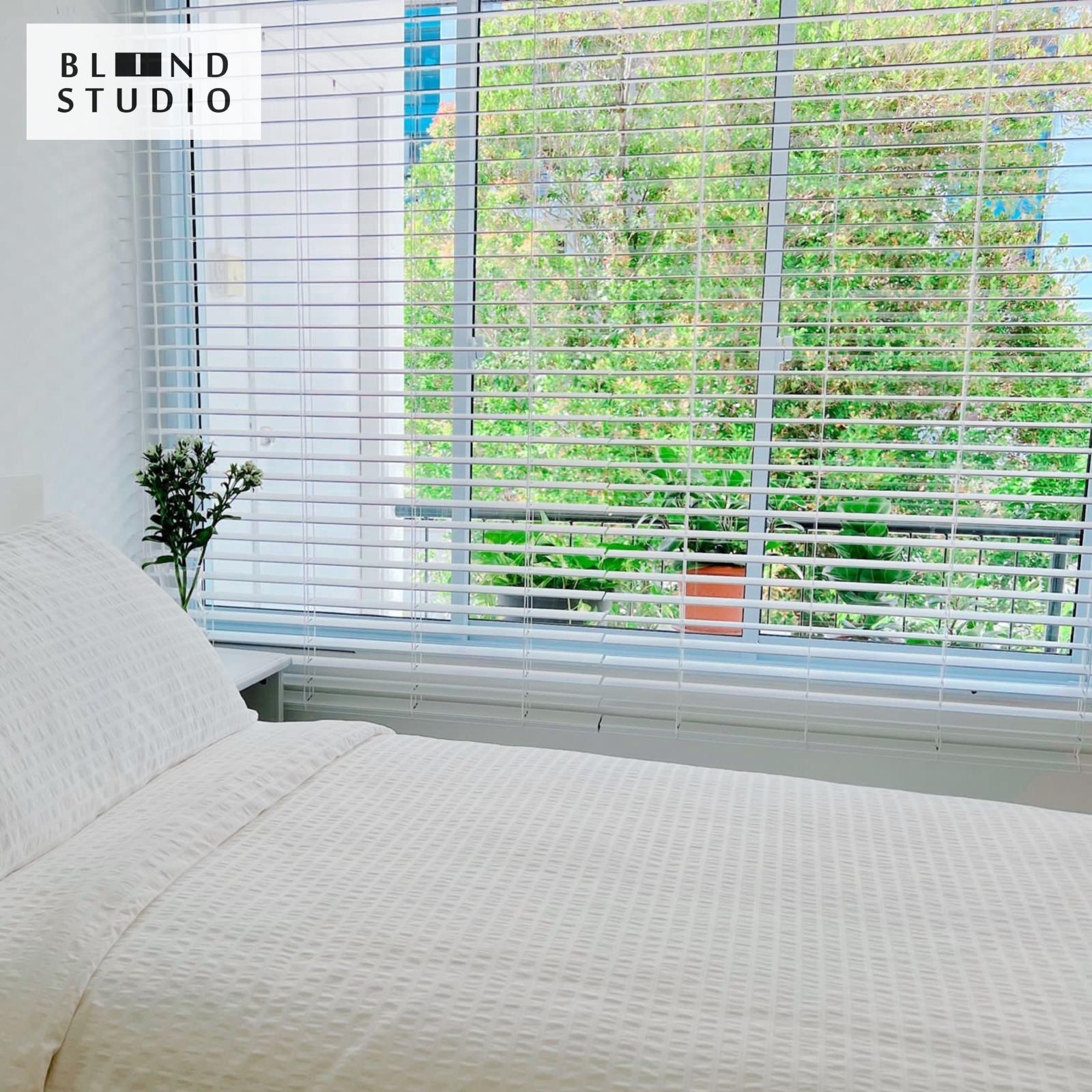 White Venetian Blinds with a white fluffy bed